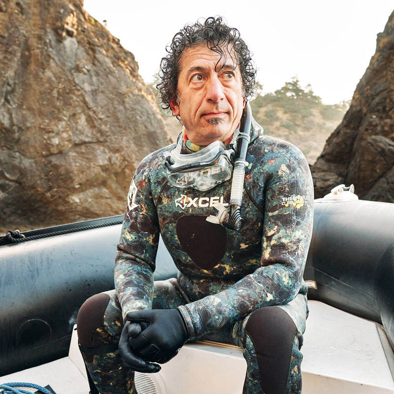 Tom Calvanese sitting on a boat in a cove near Port Orford, Oregon